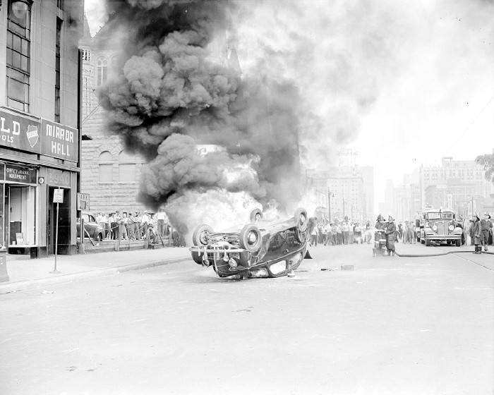 Riots: Detroit: Race Riots, 1943. June 21, 1943. Burning & Wrecked Autos. Rioters Running from Tear Gas. Burning Car on Woodward near Stimpson.