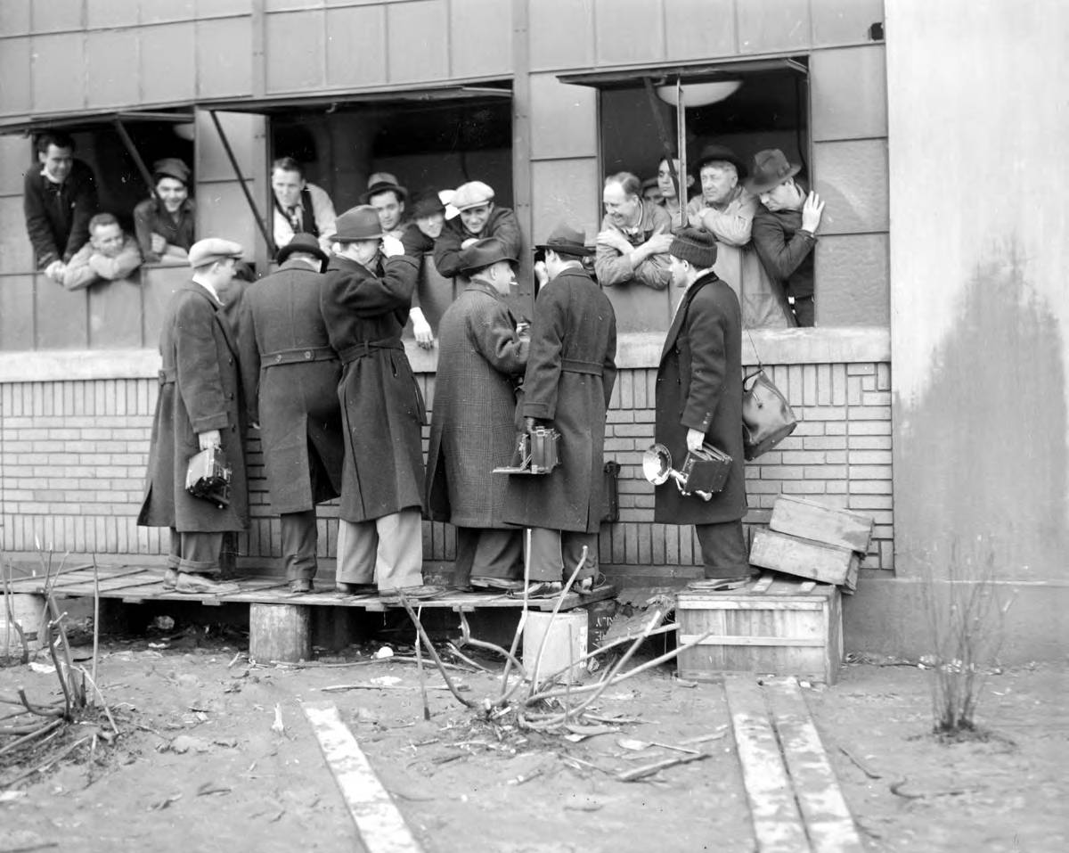 Reporters talking with Flint Sit-Down Strikers through a factory window